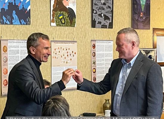 Michael O'Flaherty bekommt die Ehrennadel von Viktor Serdyuk